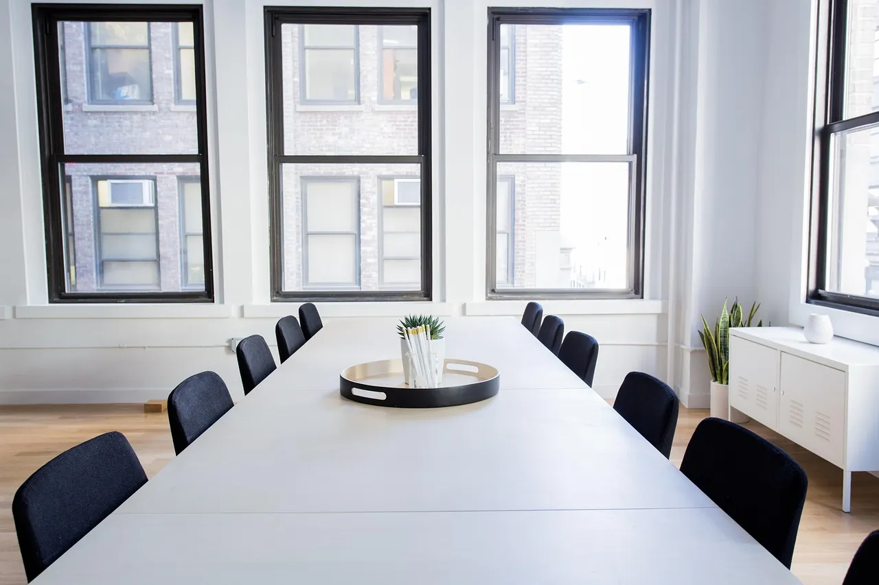 Salle de réunion vide aux grandes baies vitrées, mobilier professionnel
